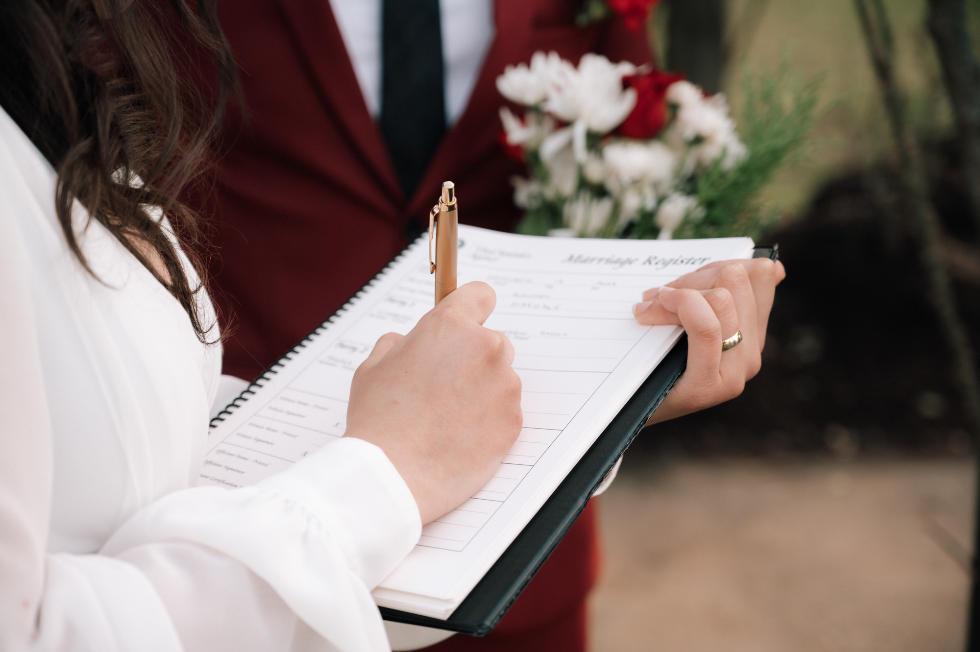 Couple signing their marriage licence with your vancouver elopement photographer