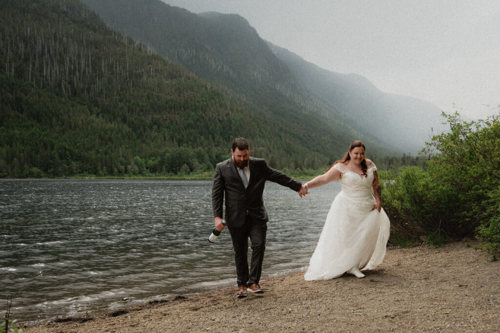 Eloping couple holdings hands by sproat lake