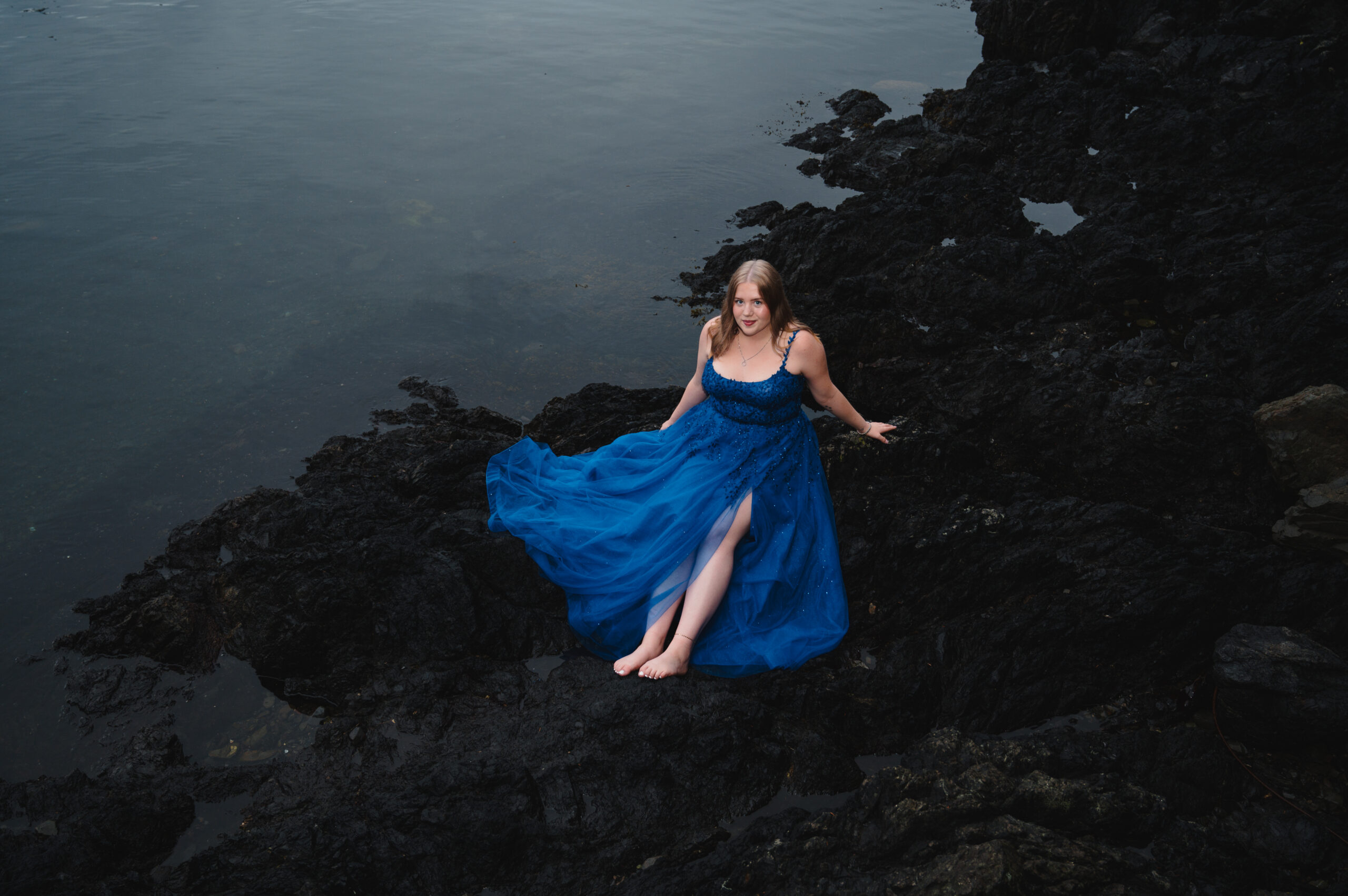 Black Rock Ucluelet by the ocean. Grad dress on sitting on rocks.